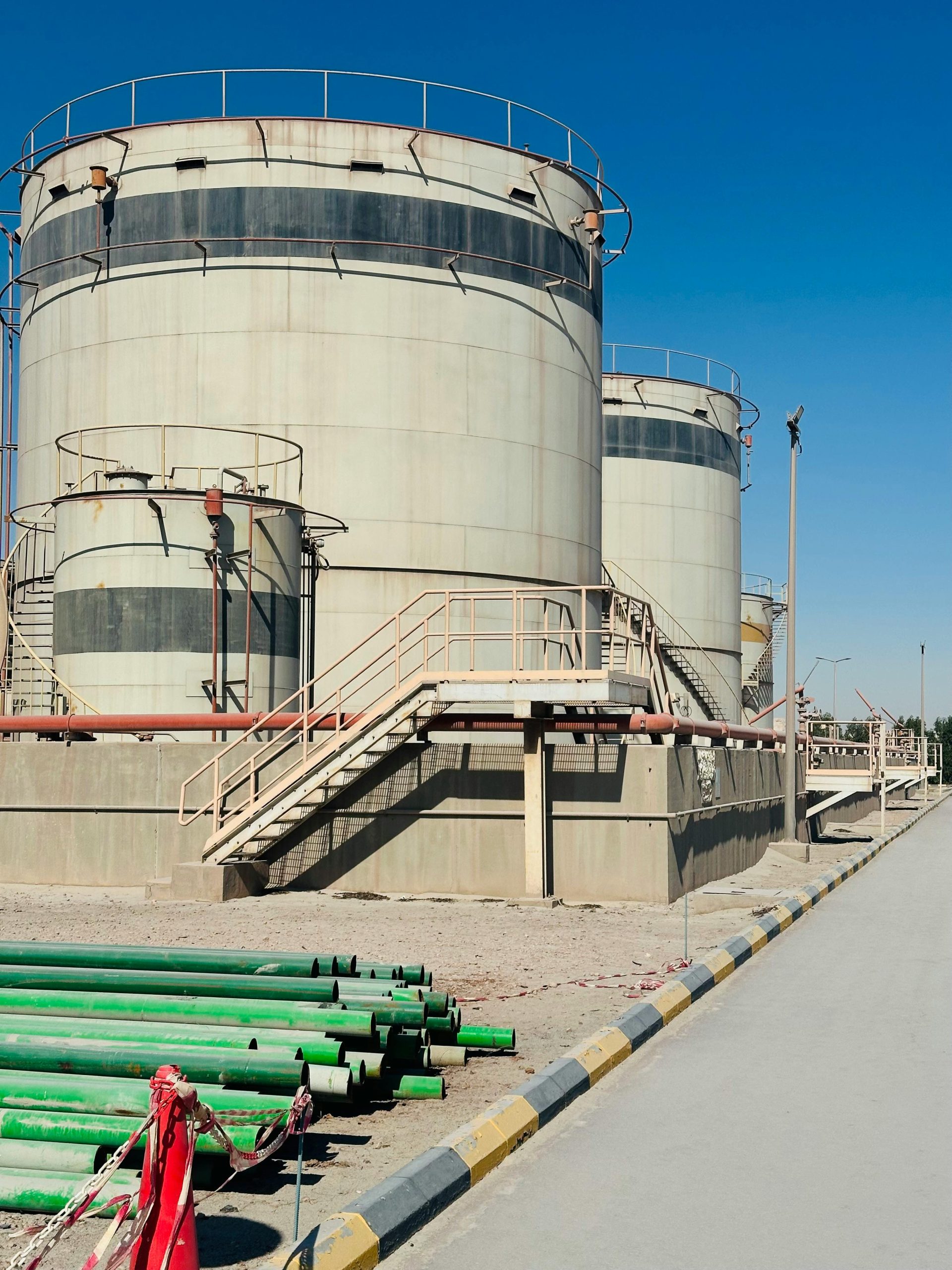 Réservoirs de stockage en Arabie Saoudite sous un ciel bleu dégagé, mettant en valeur une infrastructure industrielle avec assurance.