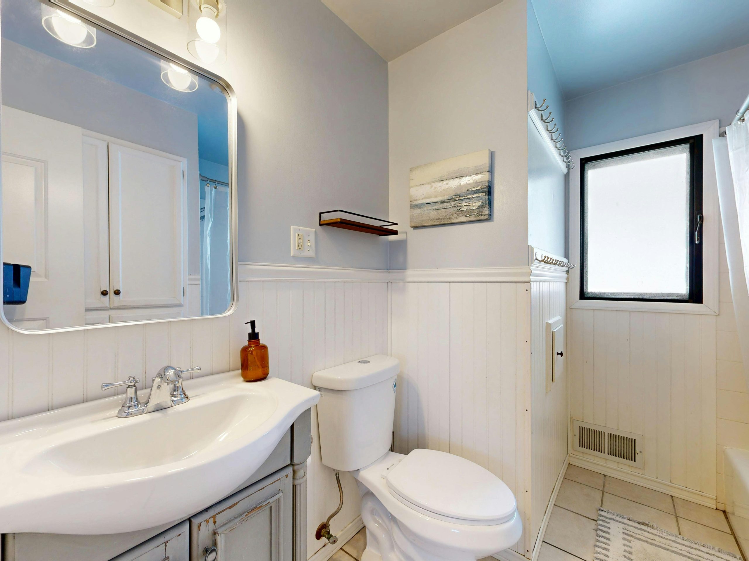 A bright, modern bathroom with a mirror, sink, and minimalist decor. Une salle de bain moderne et lumineuse avec un miroir, un lavabo et une décoration minimaliste.