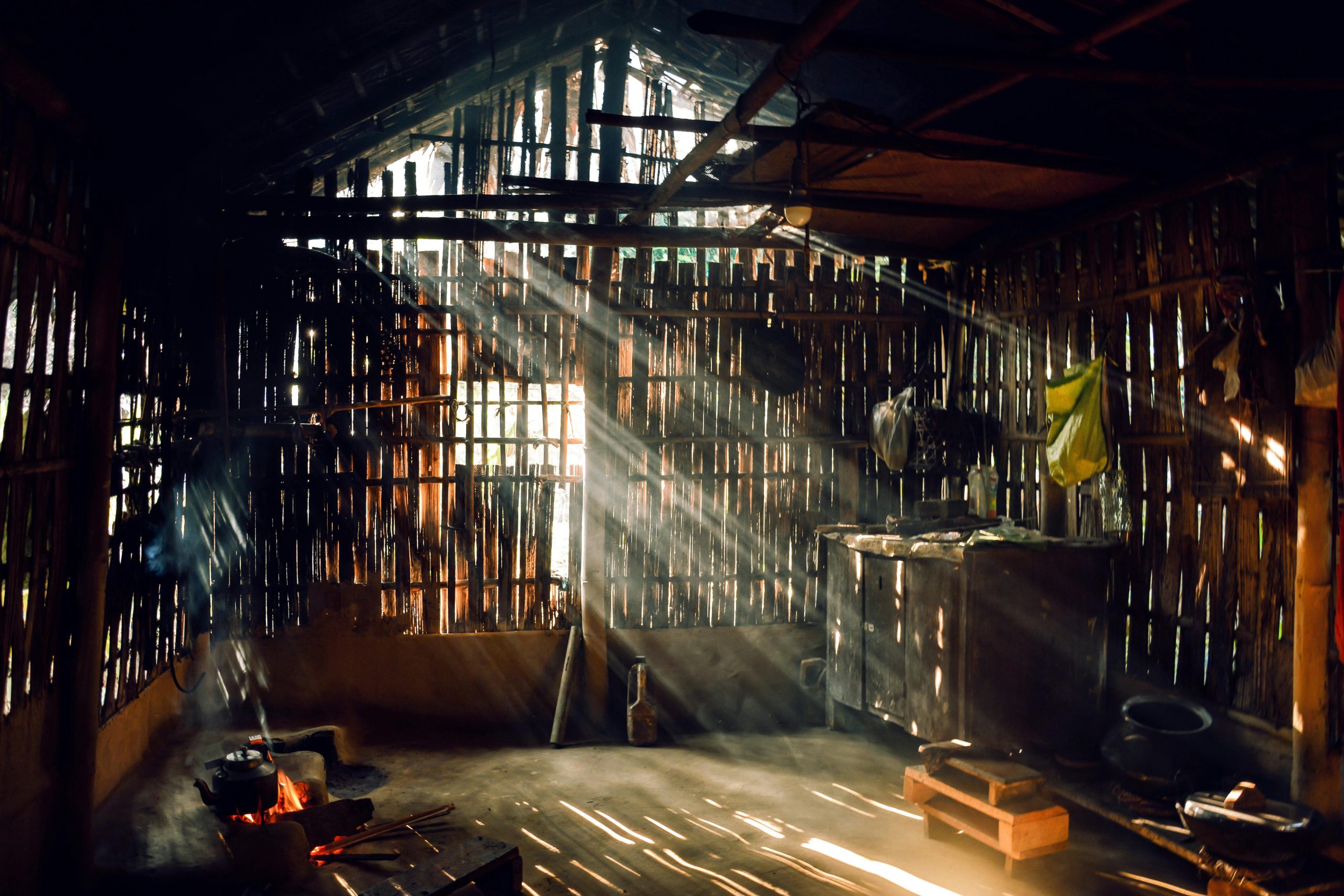 Sunlight streaming through a rustic bamboo hut creating a warm, serene atmosphere. La lumière du soleil traversant une hutte en bambou rustique créant une atmosphère chaleureuse et sereine.
