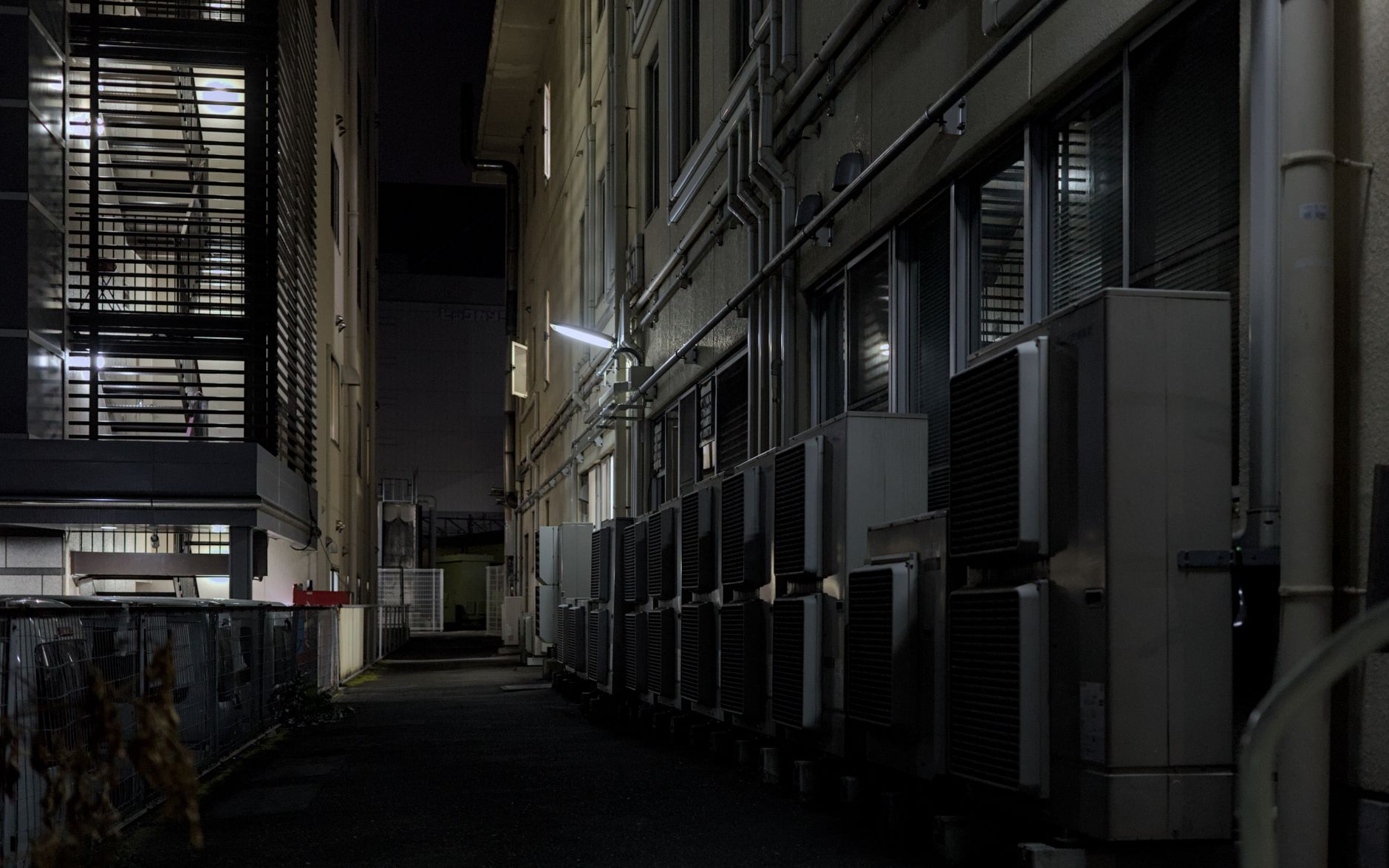 Climatiseurs extérieurs alignés sur une façade urbaine de nuit