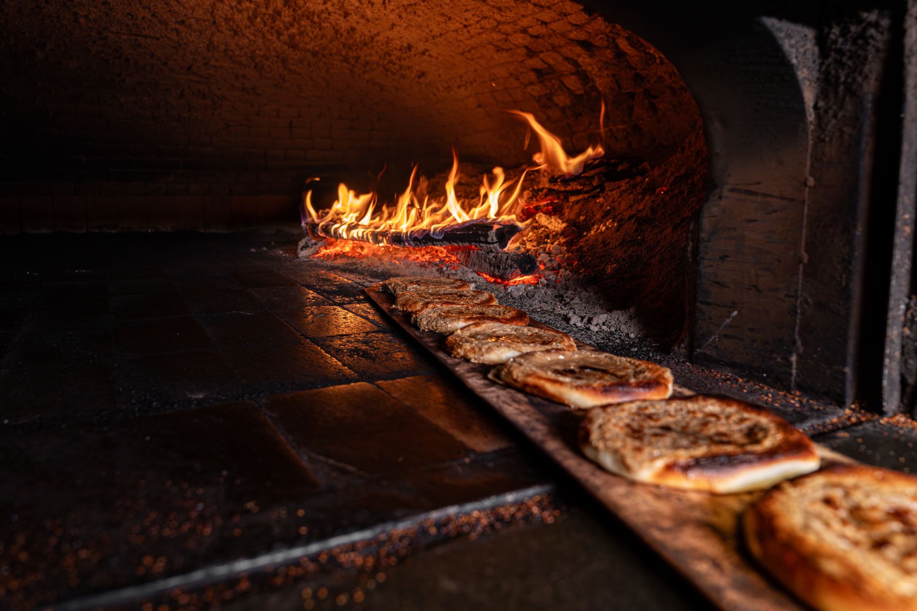 Four à bois avec pain plat en cuisson et flammes